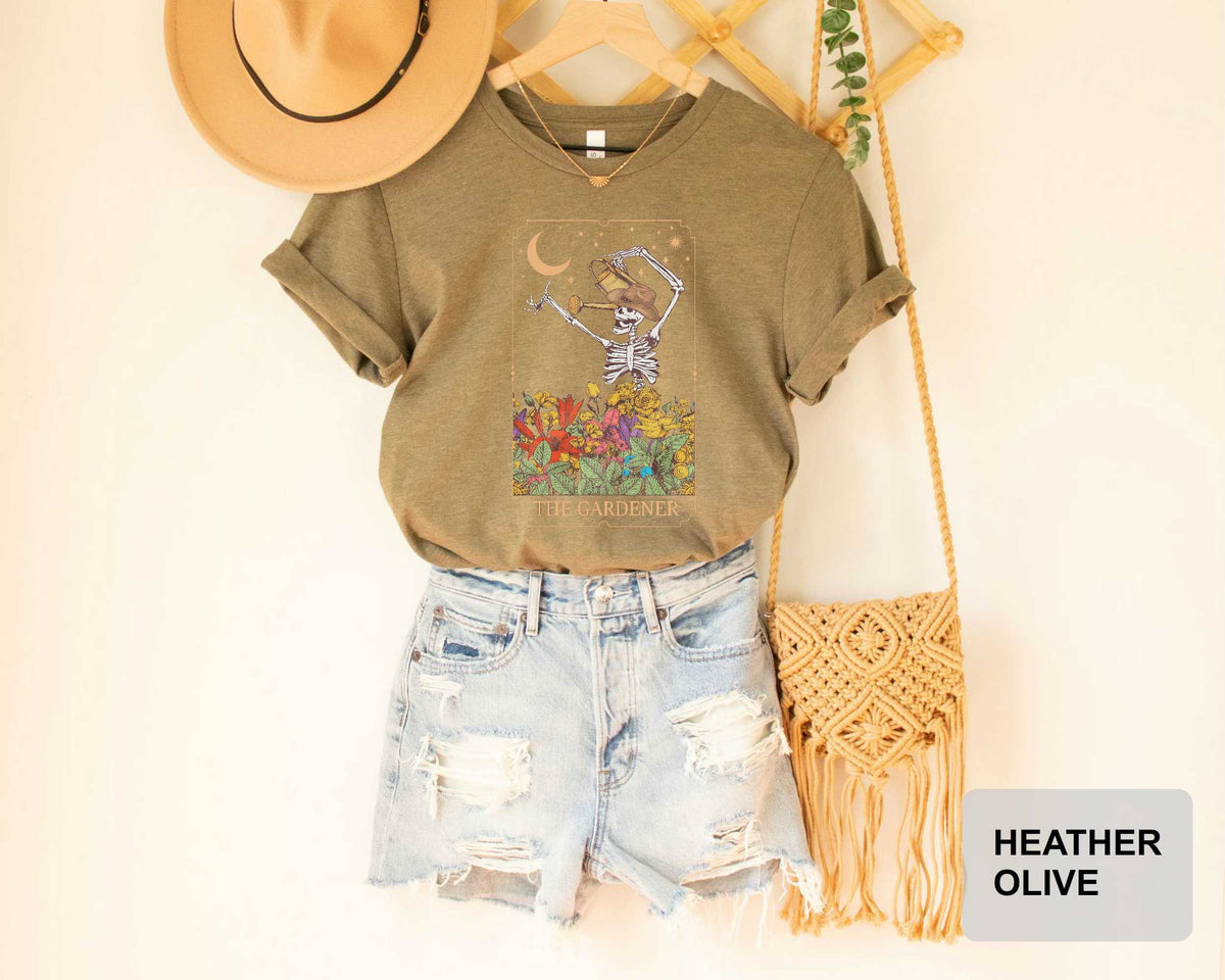 a casual outfit consisting of a t-shirt with a skeleton graphic, distressed denim shorts, and a beige hat.