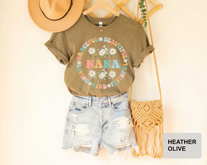 A casual outfit consisting of a t-shirt with a floral design, distressed denim shorts, and a straw boa is displayed on a hanger.